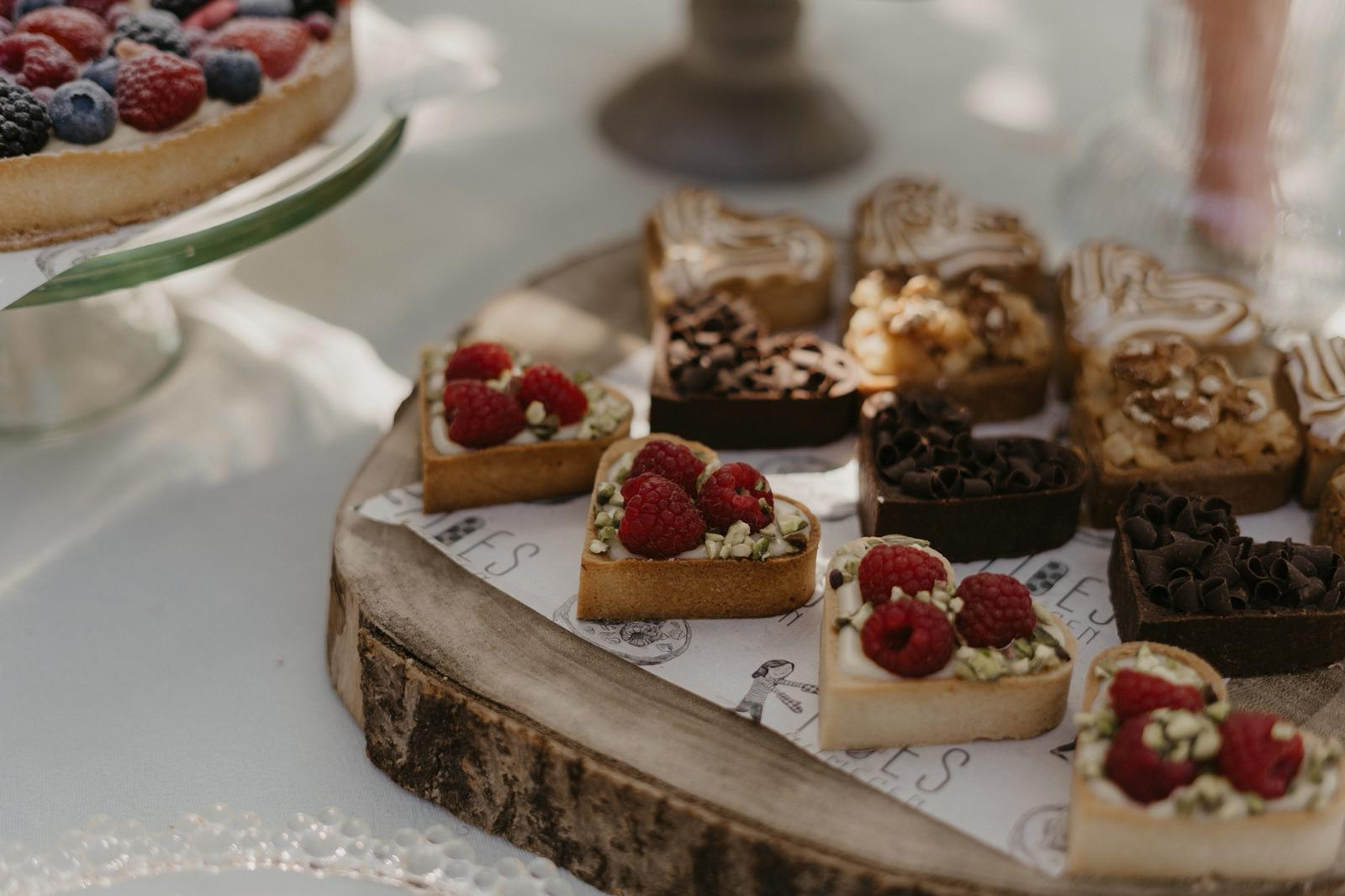 Luxe desserttafeltje met kleine taartjes en frambozen